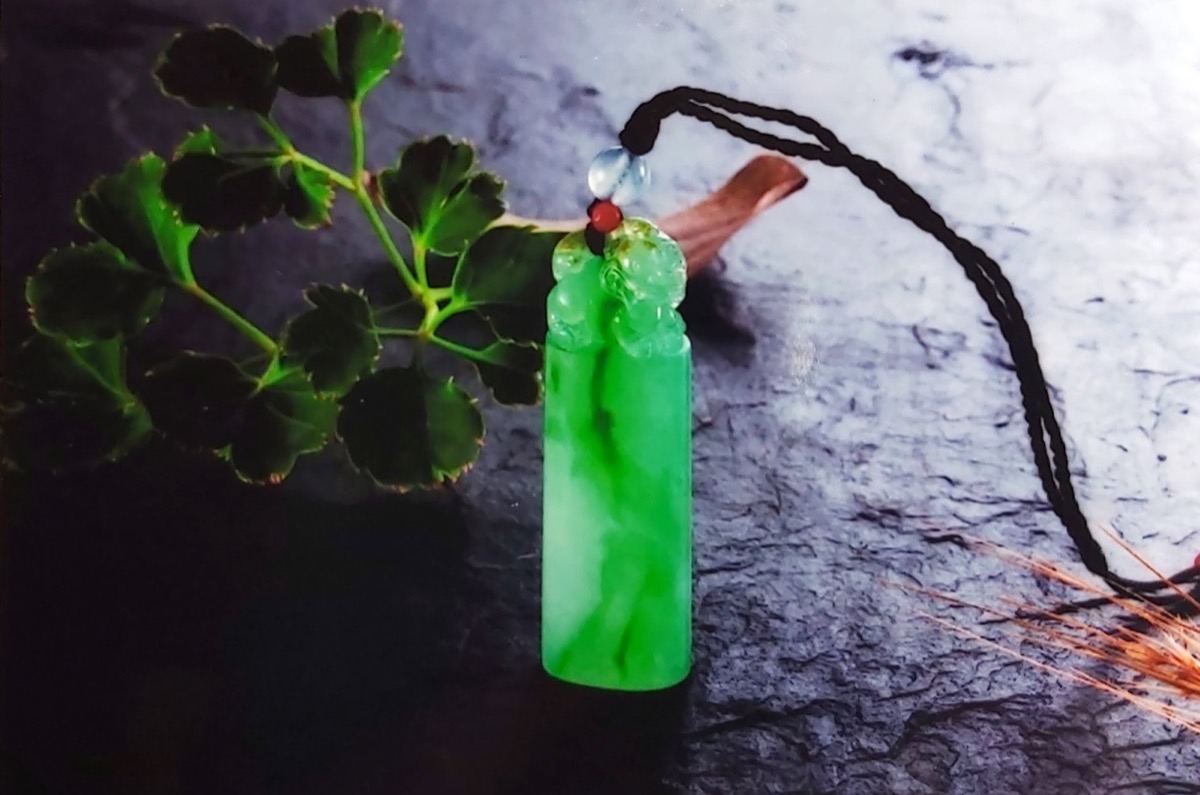 翠綠翡翠柱形墜飾與綠葉
